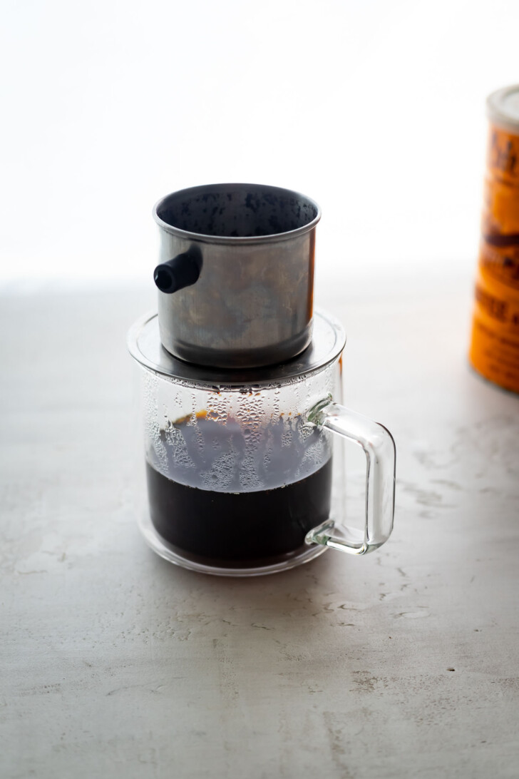 A Vietnamese coffee filter on a coffee cup.