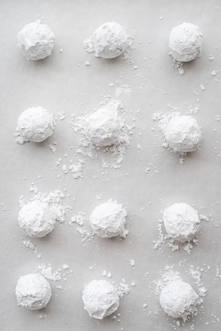 Matcha crinkle cookies at a baking sheet.