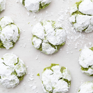 Matcha crinkle cookies on a white table.