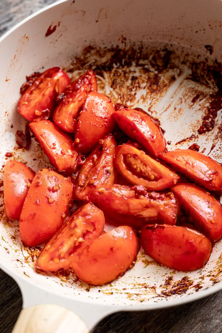 Sauteed tomatoes with tomato paste and garlic in a saute pan.