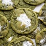 Matcha hot chocolate cookies stacked on top of each other on a white table.