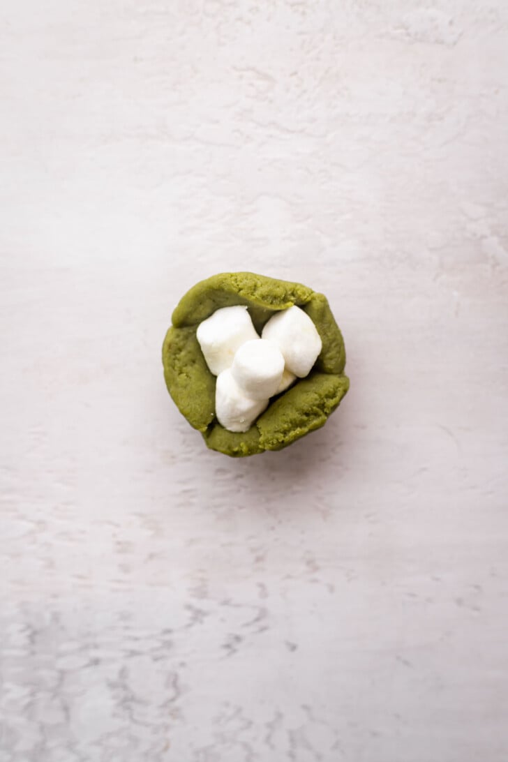 Marshmallows in the center of matcha dough.