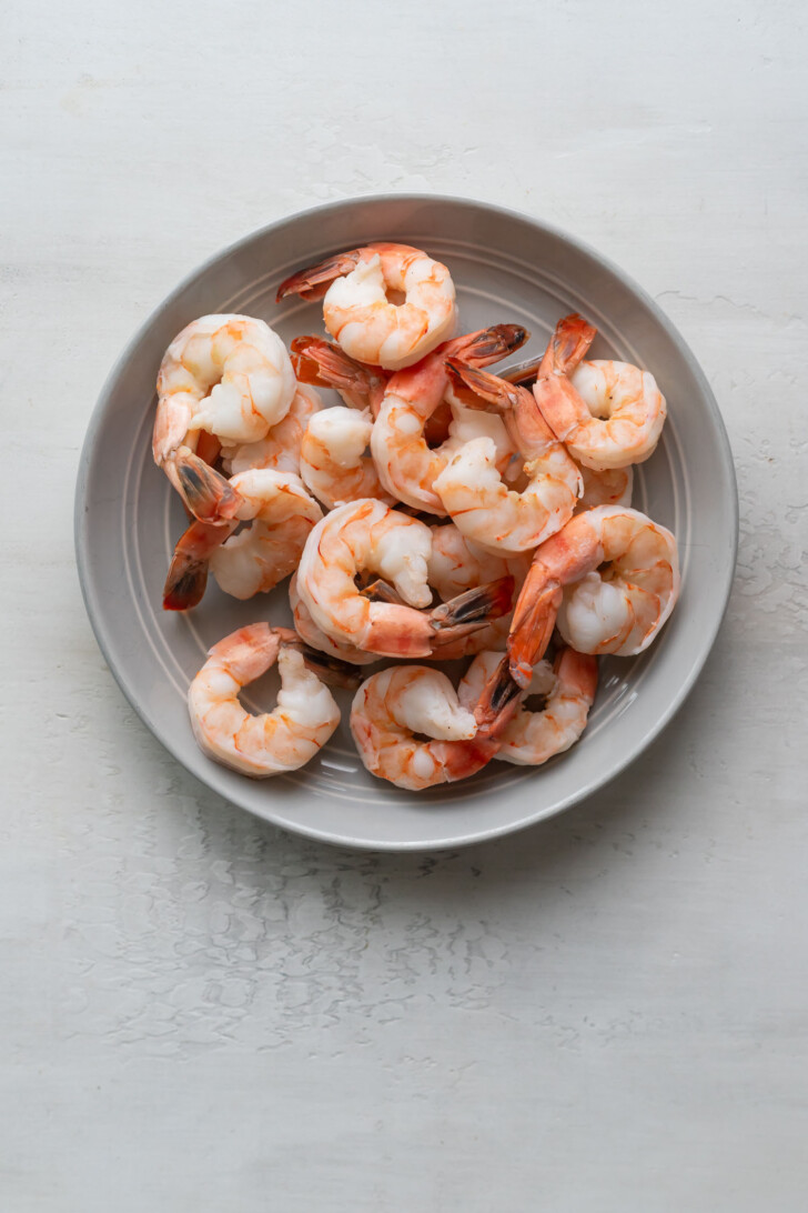 Boiled shrimp on a grey plate.