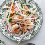 Goi Ngo Sen Tom on a plate with green flowers.