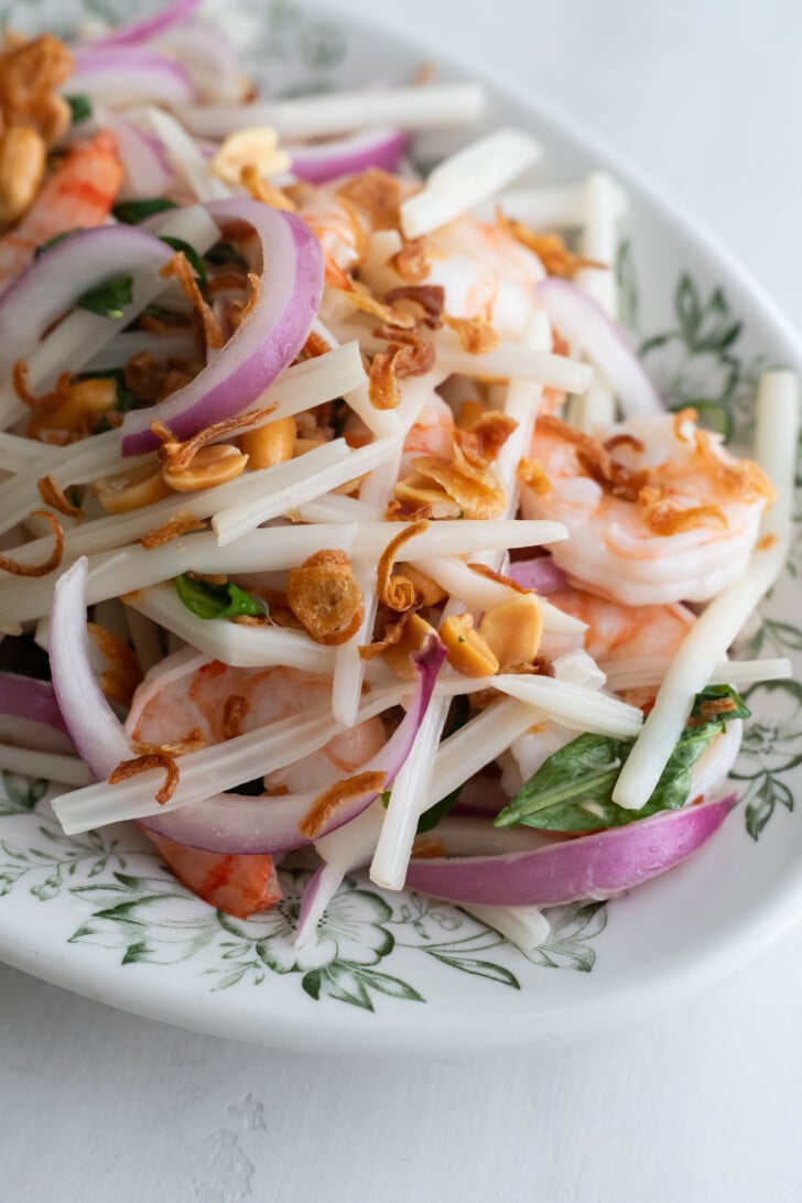 Lotus stem salad on a white plate.