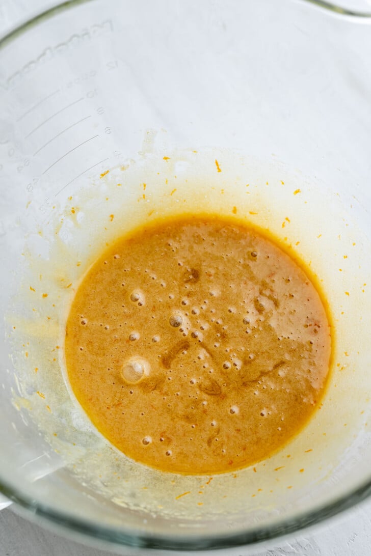 Egg, sugars, browned butter, and vanilla extract mixed together in a mixing bowl.