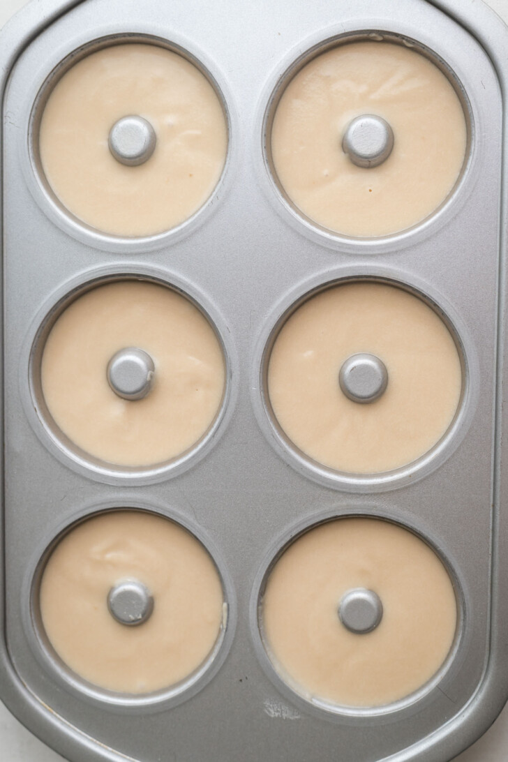 Mochi donut batter piped into a donut pan.