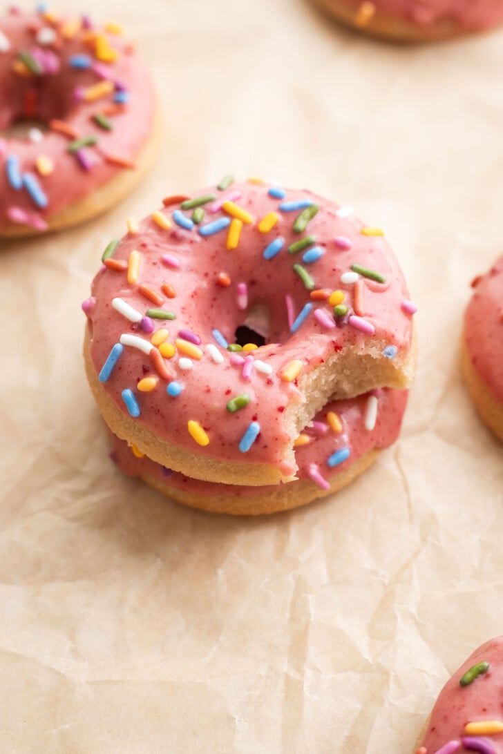 Baked strawberry mochi donuts with a bite in it.