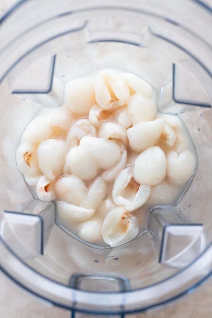 Lychee fruit and simple syrup are placed inside a blender, ready to be blended.
